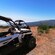 A pair of off road buggies parked on a ridge with a view of the Cabo Girao mountains